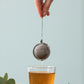 Boule à thé et verre de thé après infusion